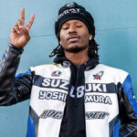 Duke Dennis posing in AMP merch, showcasing the creator behind the million dollar gamer phenomenon.