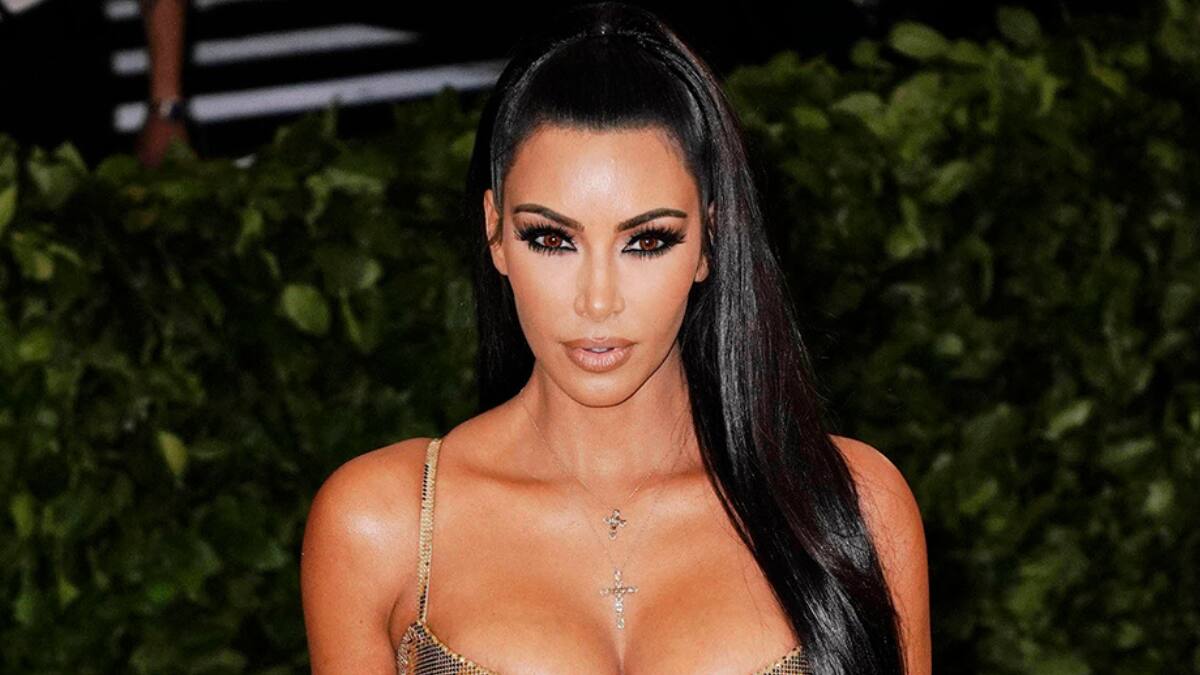 Kim Kardashian smiling in a sleek business outfit, symbolizing her $1.7 billion net worth and success with Skims and other ventures.