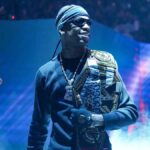 Travis Scott performing on stage with signature dark, surreal lighting and visual effects—capturing the core of his aesthetic.