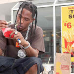 Travis Scott posing with branded collaborations including McDonald’s, Nike, and Dior — showcasing his influence across fashion, food, and culture.