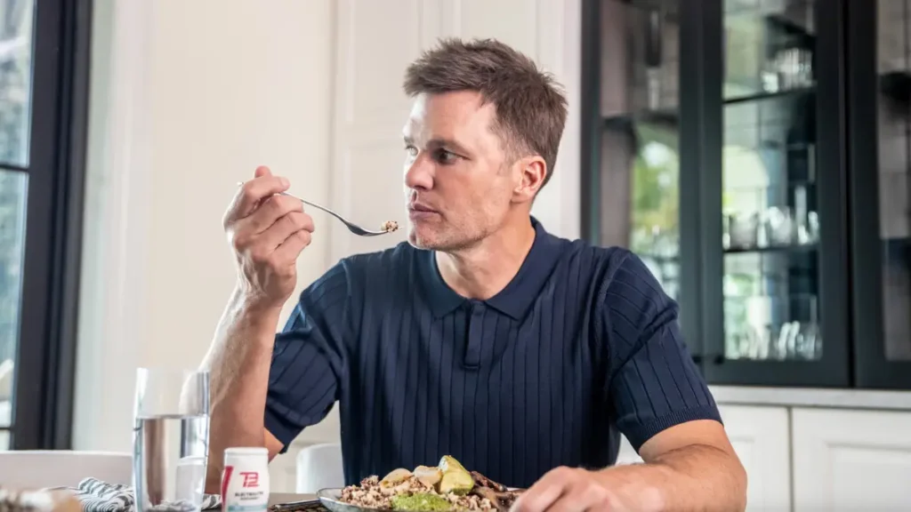 Tom Brady TB12 Diet meal plan with plant-based foods, lean proteins, and hydration essentials promoting longevity and recovery.