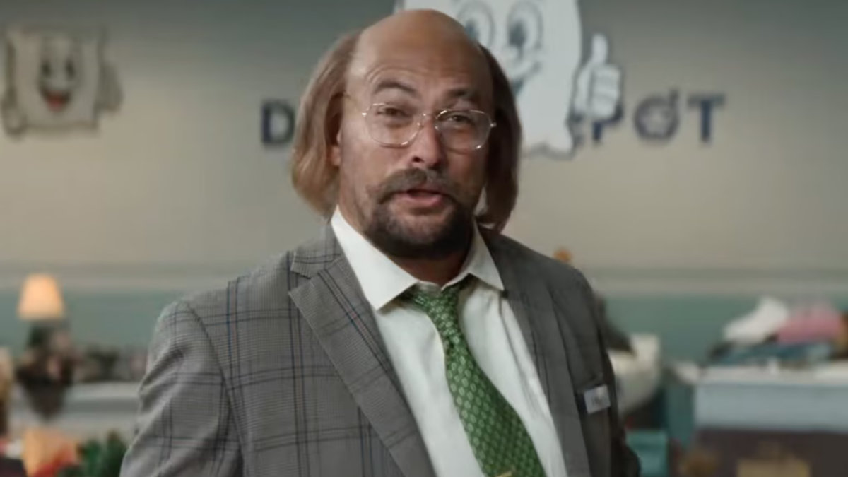 Jason Momoa standing confidently with a clean-shaven head, wearing a casual outfit, showcasing his bold new look with a slight smile.