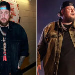 Jelly Roll smiling in a fitted black T-shirt, appearing noticeably slimmer, standing against a neutral backdrop.