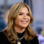 Jenna Bush Hager smiling and sitting at the Today show desk, wearing a professional outfit, as she engages with co-hosts during a live broadcast.