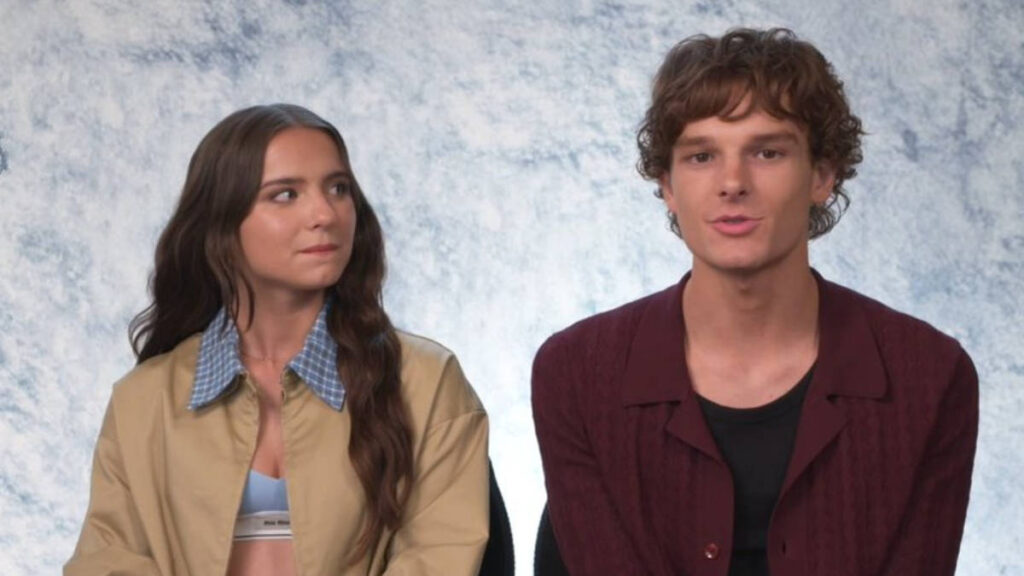 Mason Thames and McKenna Grace seated side by side during an interview, both smiling as they answer questions from the host.