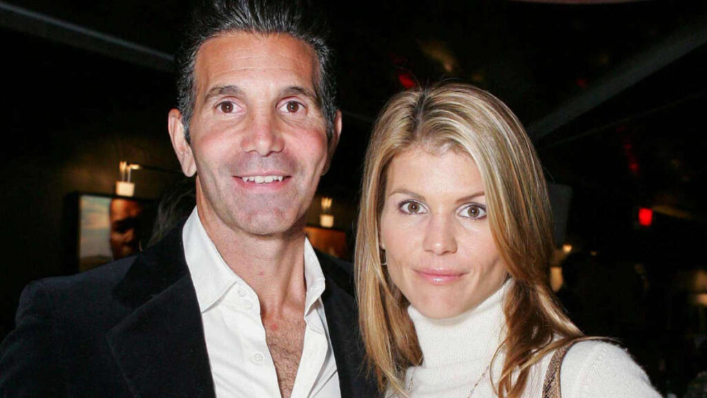 Mossimo Giannulli and Lori Loughlin share a quiet moment, holding hands