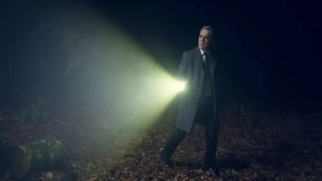 James Nesbitt scans a dark park with a flashlight in Netflix’s Run Away