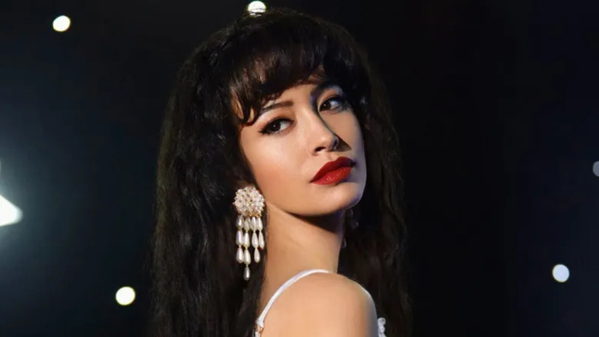 Selena Quintanilla performing on stage in her iconic purple jumpsuit, microphone in hand, with Netflix documentary title text overlaid.