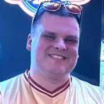 Steve Bridges smiling softly in a close-up portrait, natural window light, 2025.